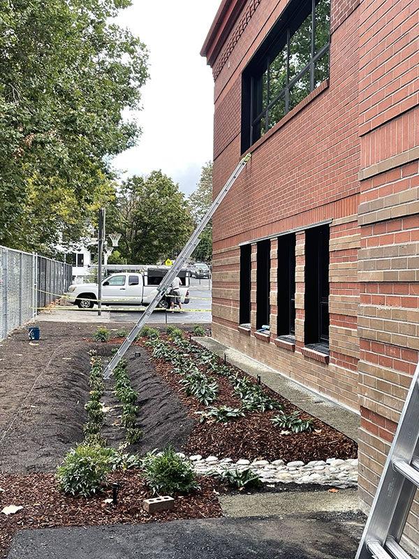 a brick building with a partially planted garden