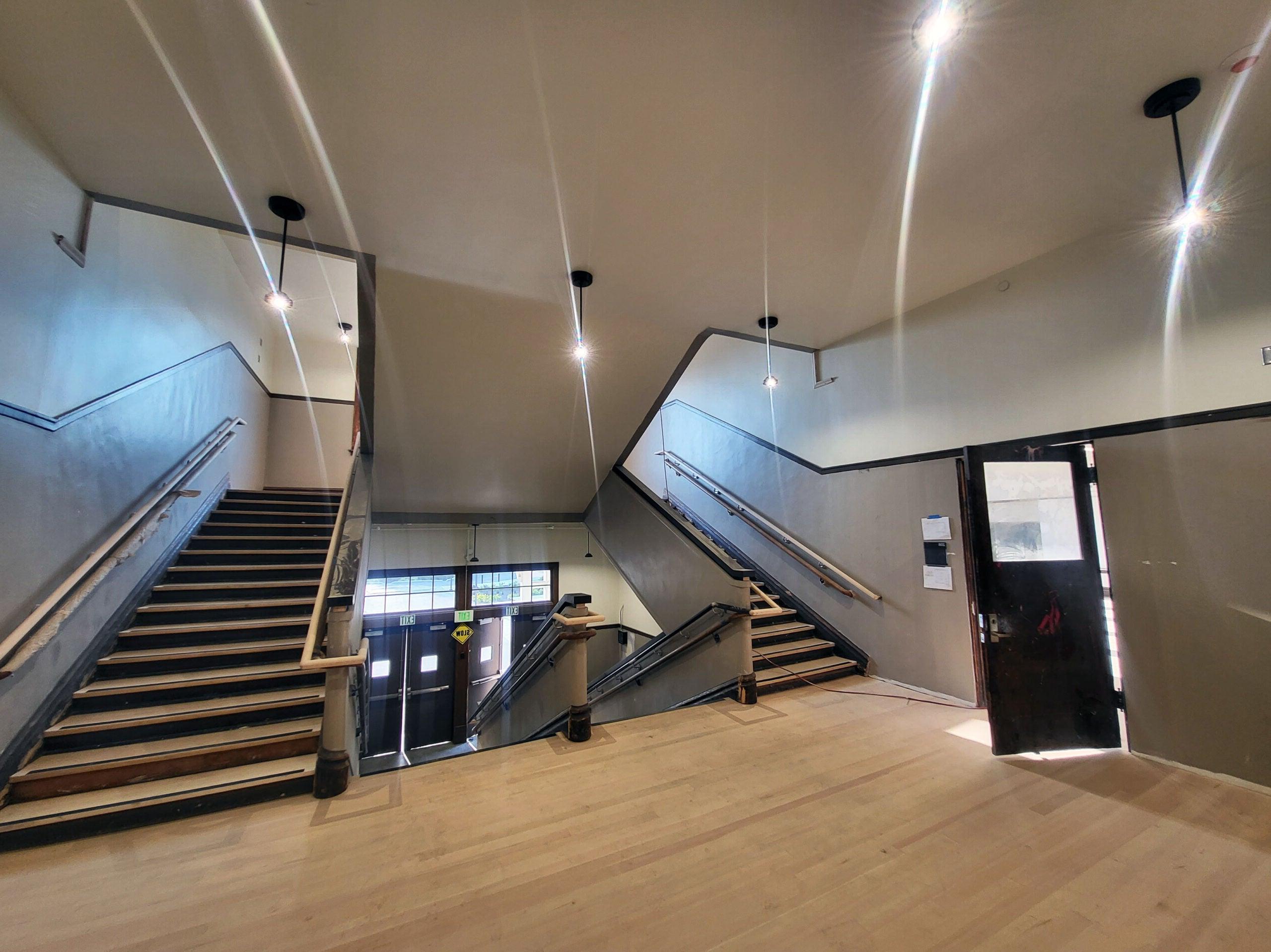 a landing with an open door to one side. stairs lead up to the landing and from the landing up to another floor