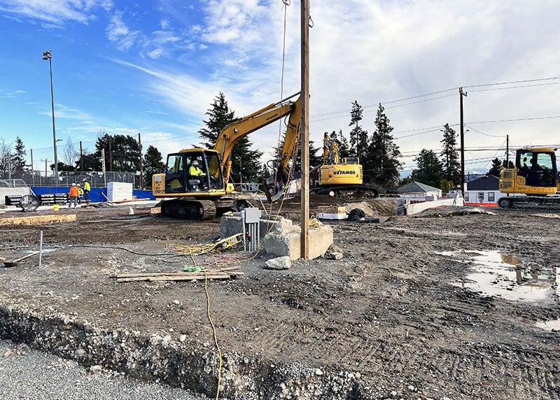 a backhoe moves soil at a construction site