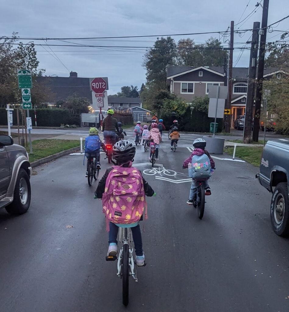 Group of student bikers on neighborhood street.