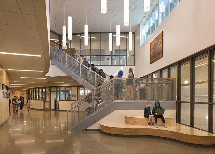 a large space with high ceilings and a stairway with lights hanging down